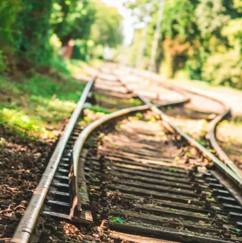 Train tracks mereging into one across a grassy landscape