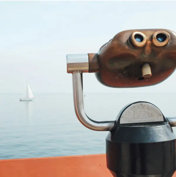 Binoculars focused on a distant boat on a lake